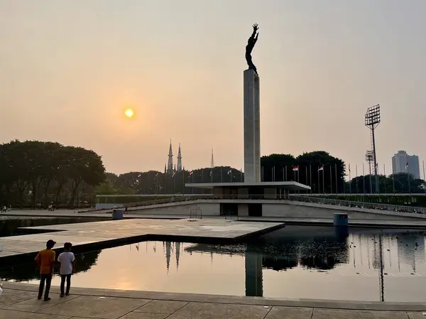 Stock image Jakarta, Indonesia - July 11th, 2024 - Monumen patung pembebasan irian barat at lapangan banteng park with sunset view. Editorial object photography isolated on horizontal background.