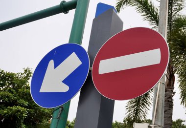 Mavi beyaz ok ve kırmızı beyaz, yatay açık gökyüzü ve ağaç yaprakları üzerinde izole edilmiş yuvarlak yol işaretine girmez..