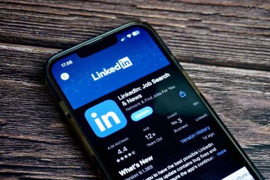 Jakarta, Endonezya - 7 Ağustos 2024 - Yatay oran kahverengi tahta yüzey arka planında izole edilmiş uygulama mağazasındaki iş portalı mobil uygulama ekranı LinkedIn.