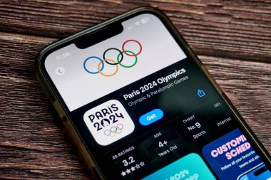 Jakarta, Endonezya - 7 Ağustos 2024 - Paris 2024 Olimpiyat ve Paralimpik Oyunları mobil uygulama ekranı yatay oran kahverengi yüzey arka planında izole edilmiş uygulama mağazasında.