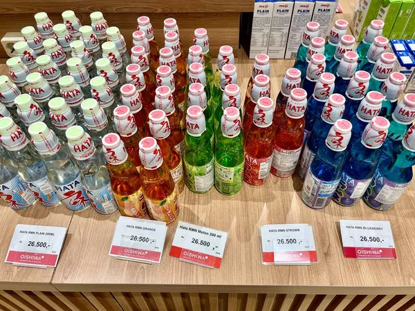 Jakarta, Endonezya - 28 Ağustos 2024 - Hata ramune meşrubatları cam şişeler içinde yatay oran süpermarket ahşap masa zemininde izole edilmiş.
