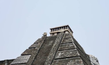 Gri taş piramit biçimli bina yapısı dış izole yatay oran düz gökyüzü arkaplanı.