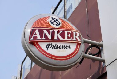 Jakarta, Endonezya - 19 Eylül 2024 - Anker Pilsener 1932 yuvarlak bar levhası açık hava mavi gökyüzü ve dış arkaplan inşaatı izole edilmiş.