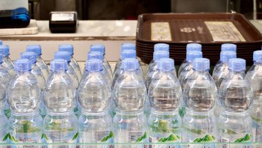 Jakarta, Endonezya - 19 Eylül 2024 - Le minerale şişelenmiş içme suyu ve yatay oran restoran kasiyeri arka planında izole edilmiş plastik mühür.