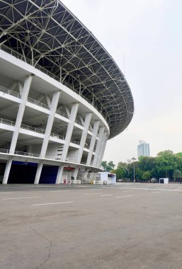 Jakarta, Endonezya - 16 Ekim 2024 - GBK Stadyumu Gelora Bung Karno bölgesinde dikey arkaplanda izole edilmiş yuvarlak bina dış ve asfalt yol.