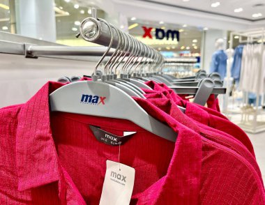 Jakarta, Indonesia - November 5th, 2024 - Pink hanging clothes display isolated on horizontal ratio max fashion retail clothing store interior background. clipart