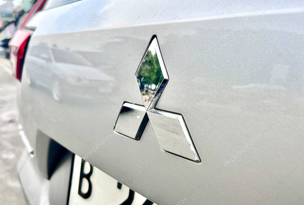 Jakarta, Indonesia - November 3rd, 2024 - Mitsubishi car logo silver sign on car body surface isolated on horizontal ratio background.