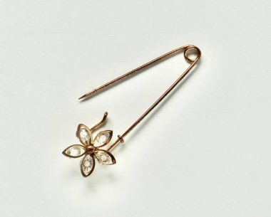 Yatay beyaz arkaplanda izole edilmiş çiçek desenli bir açık metal broş..