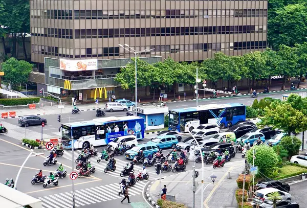 Jakarta, Endonezya - 19 Kasım 2024 - Sarinah alışveriş merkezinin önündeki birçok aracın bulunduğu işlek cadde.