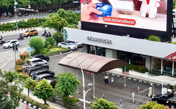 Jakarta, Endonezya - 19 Kasım 2024 - Starbucks Sarinah kahvecisi dış görünüşü şehir arka planında izole edildi.