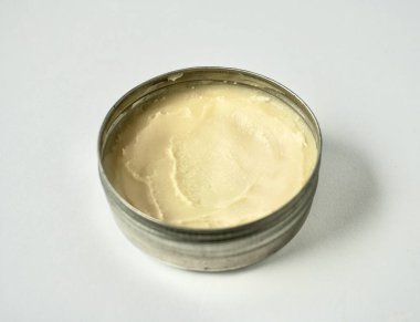 Yatay arkaplanda izole edilmiş metal teneke kavanoz kabı içindeki deodorant kremi cilt bakımı ürünü.