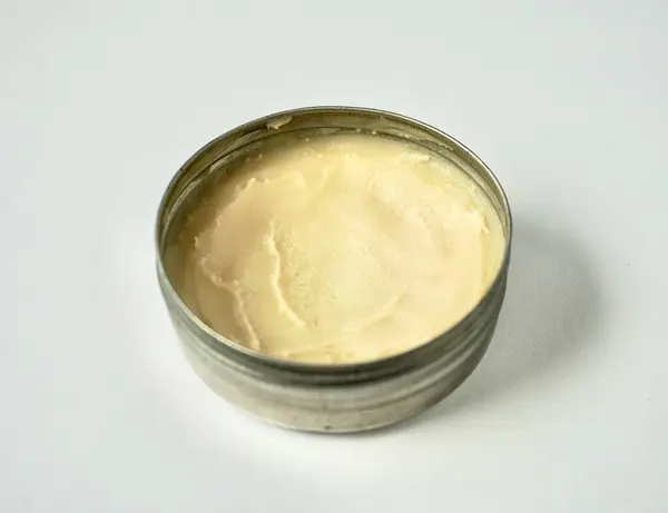 Yatay arkaplanda izole edilmiş metal teneke kavanoz kabı içindeki deodorant kremi cilt bakımı ürünü.