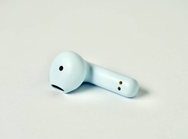 One piece of wireless blue bluetooth earphone isolated on horizontal white background. clipart