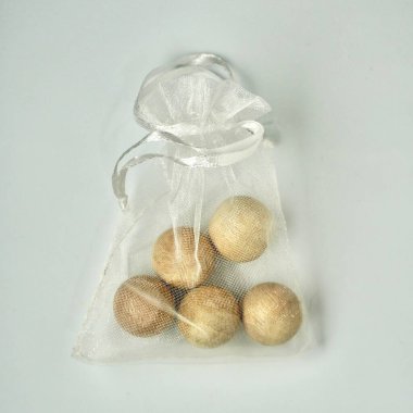 Anti smell odor and insect wooden balls for replacing camphor in white transparent pouch bag isolated on square white background from above angle view. clipart