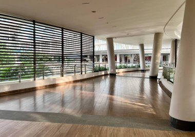 Jakarta, Endonezya - 7 Ocak 2025 - Tribeca Park Central Park Alışveriş Merkezi 'ndeki kolonlar ve çizgili pencere ayırıcılı ahşap patika yolu yatay arka planda izole edildi.