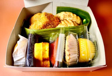 Geleneksel Endonezya tatlıları. Jajanan pasar yatay turuncu kahverengi arka planda izole paket.