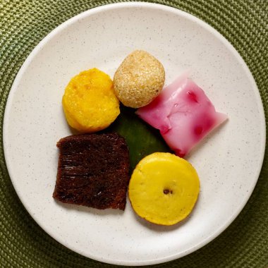 Endonezya tatlı jadana pasar geleneksel yemek aperatifleri kare yeşil yuvarlak tabak kapalı üst açı görünümlü dairesel plasemat.