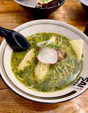 Jakarta, Endonezya - 30 Mayıs 2025 - Sai ramen restoranında yeşil pesto ramen menüsü aeon alışveriş merkezi dikey ahşap masa arkasında izole.