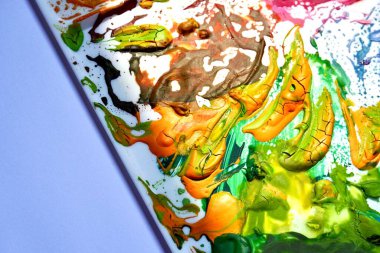 Plastik palette kurumuş kahverengi, sarı ve yeşil kalın guaj boyası var. Yatay arkaplanda izole edilmiş sanatçı veya boyacı ekipmanı nesnesi.