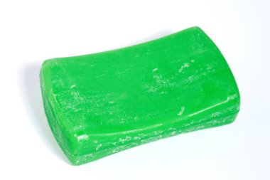 Yatay beyaz arkaplanda izole edilmiş yeşil renkli sabun çubuğu.