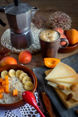 Breakfast porridge with fruit, cheese, eggs and coffee.