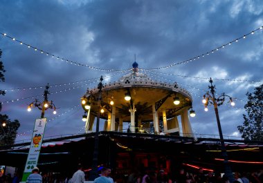 September 2022 - Albacete, Spain - City celebration with carousels and historical costumes. The building is historical with a dome and decorated with festive lights