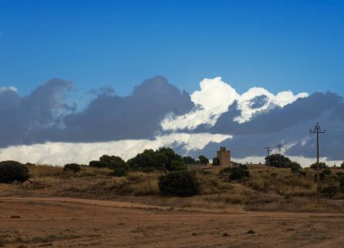 Ancient windmill and power line in the background of the evening sky