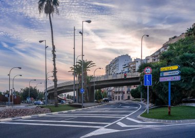 October 2022 - Alicante, Spain - Spanish city of Alicante, road junction on the street with overpass, road signs, sound barriers and markings at sunset