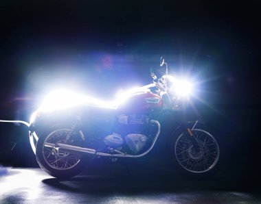 February 2022 - Albacete - Red classic motorcycle Triumph Bonneville T100 in the dark 