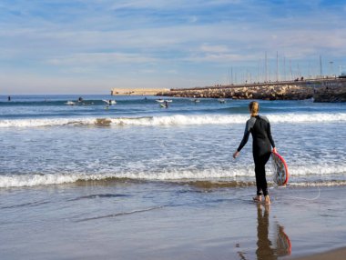 Aralık 2022 - Valencia, İspanya - Yürüyen insanlar ve sörfçülerle dolu Akdeniz