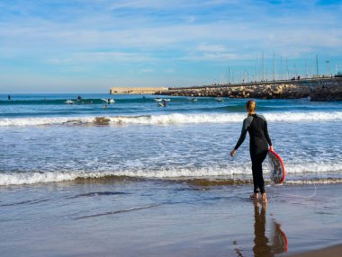 Aralık 2022 - Valencia, İspanya - Yürüyen insanlar ve sörfçülerle dolu Akdeniz