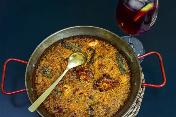 Aralık 2022 - Valencia, İspanya - Geleneksel İspanyol paella 'sı ve bir restoranın terasında bir bardak şarap