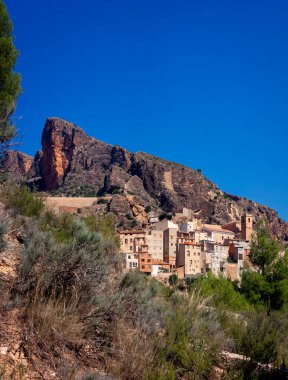 Güneşli bir günde dağın eteğindeki köy manzarası