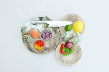 Ceviche tarifi için ahşap kaplamalı ve renkli yaz peçeteli güzel ve renkli malzemeler, büyük bir bıçak. Parlak profesyonel stüdyo ışıklandırması ve beyaz arka plan.