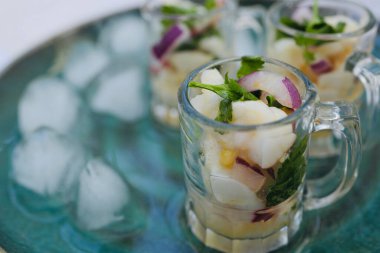 Buzlu yeşil bir tabakta deniz tarağı ceviche ile cam bardağı kapat.. 