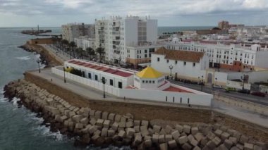 Bulutlu bir günde Cdiz 'in kıyılarını bu 4K İHA videosuyla deneyin. Deniz manzaraları, kıyı manzaraları ve İspanyol seyahat projeleri için mükemmel..