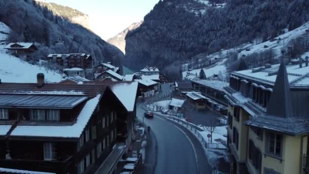 この4Kドローンビデオで冬の旅に出かけ ラウターブレンデンの雪に覆われた通りを飛び回ります アルプスの風景 スイスの村を扱うプロジェクトに最適 — ストック動画