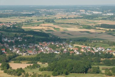 Güneşin altında, yoğun ormanlar ve genişleyen manzaralarla çevrili sakin bir Alman kasabasını yakalıyor..