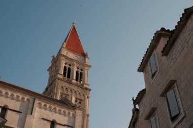 Görüntü, Trogir 'in ünlü Clocktower' ının büyüleyici ev cephelerinin ortasındaki bu tarihi Hırvat kasabasının tadına varmasını sunuyor..