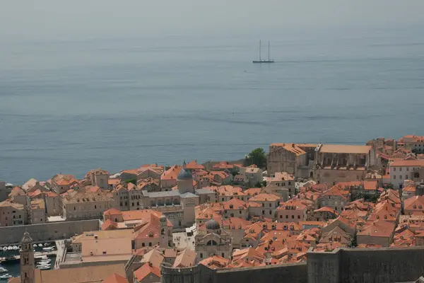Güneşli bir yaz gününün ılık güneş ışığı altında, Dubrovnik 'in tarihi evleri dimdik ayakta duruyor, kırmızı kiremitli çatıları cazibeyle parlıyor..