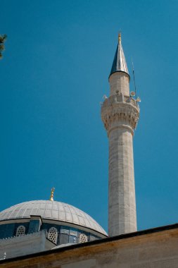 Güneşli bir günde görkemli bir geleneksel Türk camisi açık mavi bir gökyüzüne karşı dimdik ayakta duruyor. Mimari ihtişamı ve zarif minareleri güzeldir..