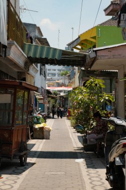 Malang, Endonezya 'da güneşli bir geçitte keyifli bir yürüyüşe çıkın. Bu dar, yürünebilir yol, insanları cazibesini keşfetmeye çağıran dostane bir hava yayıyor..
