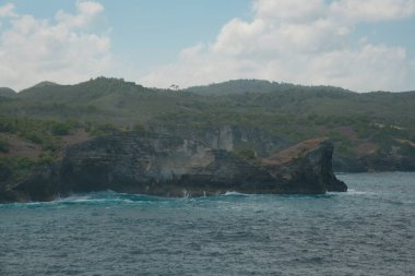 Doğanın görkemli bir doğal kemer yonttuğu, Nusa Penida adlı kırık plajın hayranlık uyandıran güzelliğini keşfedin. Turkuaz sulara bakan