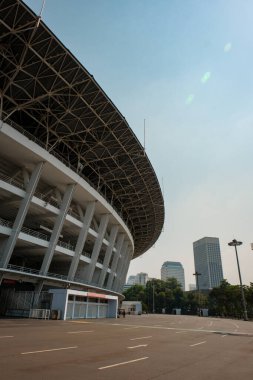 Gelora Bung Karno Stadyumu 'nun heybetli heybetini karşı kanattan deneyin. Boş araziler stadyumun mazisini yansıtıyor.