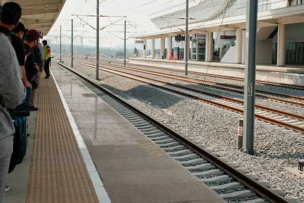 Train İstasyonu 'na' Whoosh 'hızlı treninin gelmesini hevesle bekleyen yolcuların beklentilerini havada hissedin..