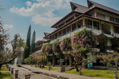 ITB kampüsündeki Hollanda sömürge mimarisi, Bandung, Endonezya, açık bir günde canlı pembe çiçeklerle zenginleştirilmiş, tarihi doğal güzelliklerle harmanlıyor..