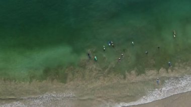 İnsansız hava aracı yukarıdan aşağı doğru bir çekim yaparken, Lombok 'un Endonezya' daki el değmemiş kumsalının panoramik ihtişamını ortaya çıkarmak için zarif bir şekilde yüzeye çıkıyor..