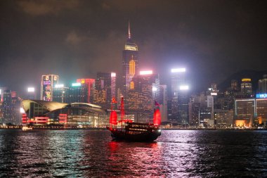 Gecenin karanlığında, Hong Kong 'un ufuk çizgisi denizi aydınlatıyor, sulara göz kamaştırıcı bir ışık yansıtıyor..