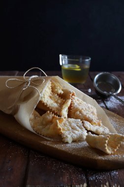 Homemade traditional Italian carnival sweets - chiacchiere dusted with powdered sugar. Italian food.