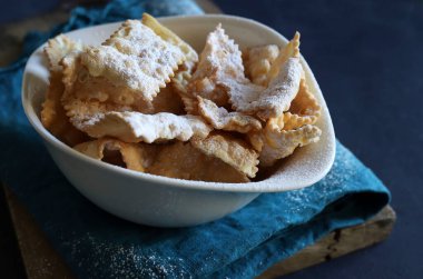 Homemade traditional Italian carnival sweets - chiacchiere dusted with powdered sugar. Italian food.